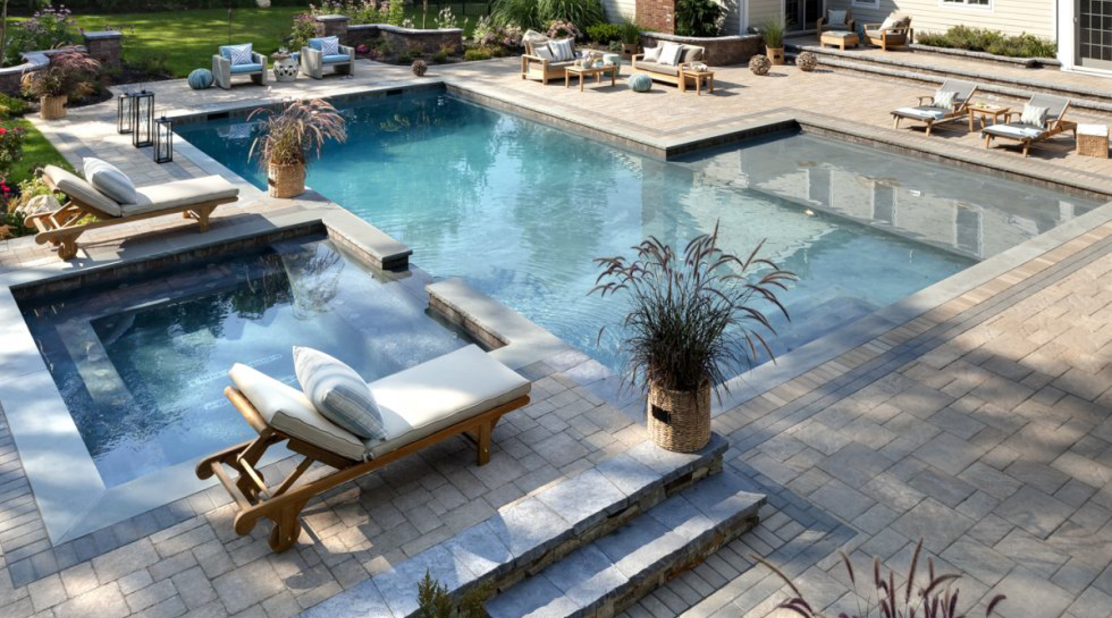 Swimming pool with a spa, lounge chairs, and a stone terrace